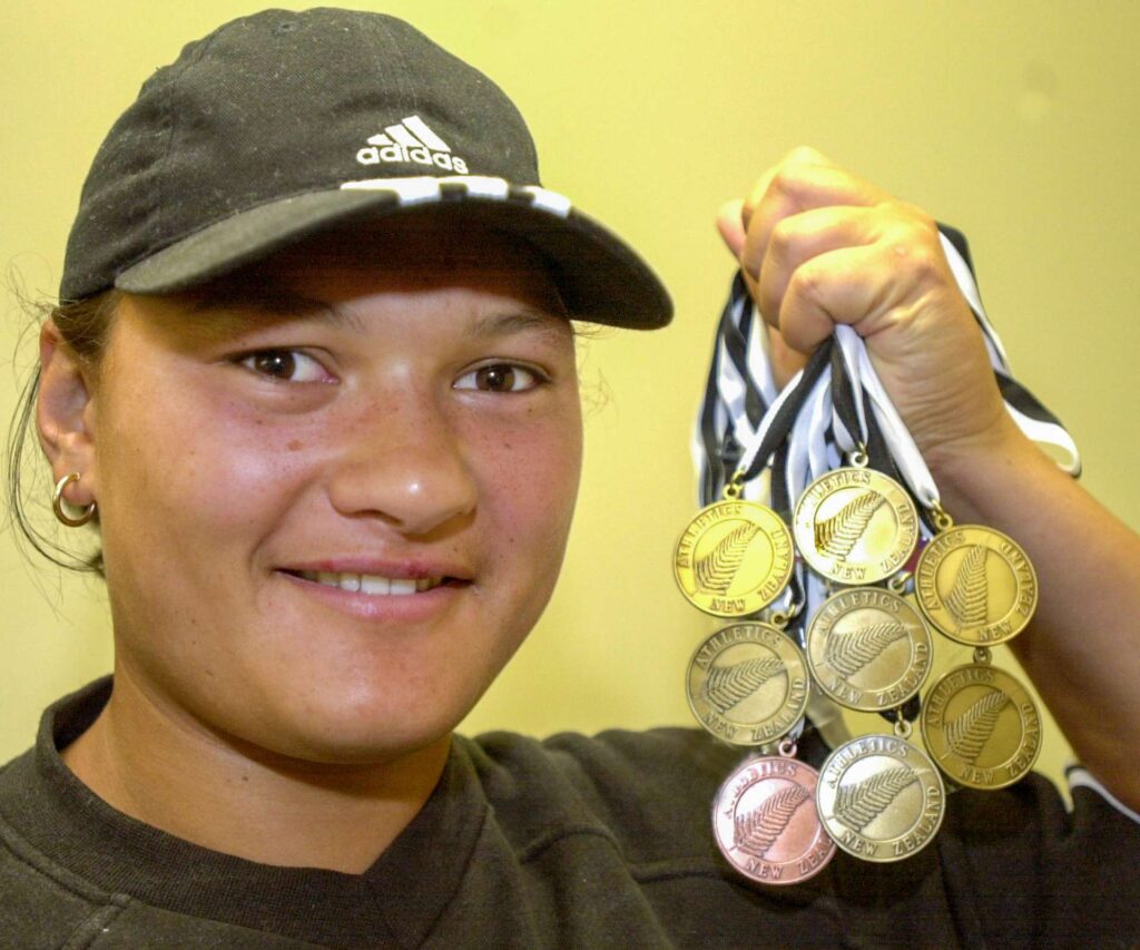 Young Valerie Adams holding up 8 medals