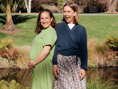 Two Raw Sisters Rosa and Margo in front of a river, Rosa cradling her baby bump